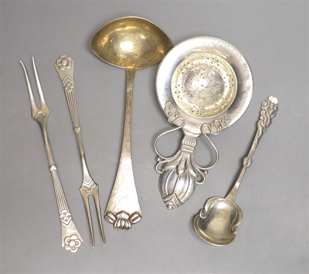 A stylish early 20th century Danish white metal tea strainer, 14.7cm and four other similar items of flatware, 5oz.